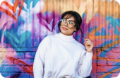 Imagen de mujer recostada en una pared